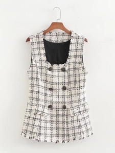 Detailed macro view of beige tweed vest with black plaid pattern and frayed edges