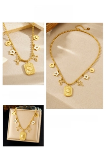 Detail of beaded gold necklace featuring sun relief pendant, moon and star charms