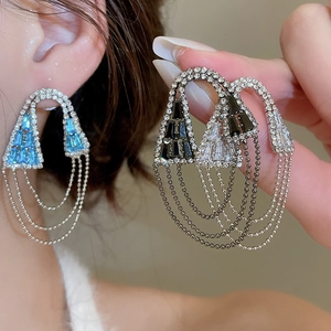 Détail macro des boucles d'oreilles géométriques à glands avec cristaux et chaînes