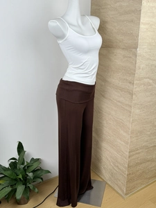 Side view of brown wide-leg flared trousers paired with white camisole on a mannequin