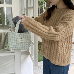 Detail of light green bubble texture canvas tote bag with metal zipper and woven label