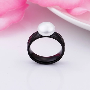 Detail of a textured black stainless steel ring with a round white pearl inlay