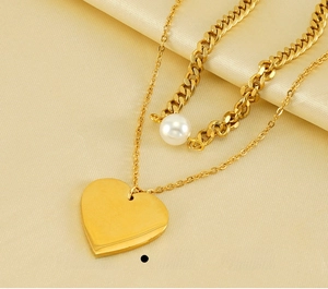 Macro shot of double-layer gold heart necklace with pearls on premium champagne silk