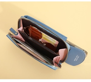 Detail view of open blue PU leather crossbody phone bag with card slots and inner pink lining