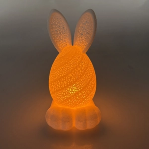 3D printed LED Easter bunny lamp with hollow egg shape emitting warm orange glow