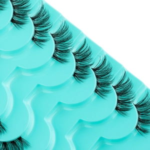 Detailed macro view of black synthetic false eyelashes on a teal plastic tray base