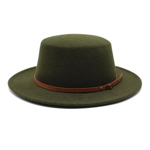 Détail d'un chapeau plat en laine vert foncé avec une bande décorative en cuir brun