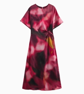 Detailed view of red silk satin dress featuring waist twist pleats and tie-dye print