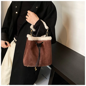 Brown suede bucket bag with white faux shearling trim and adjustable drawstring closure