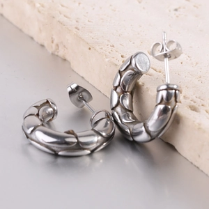 Macro shot of silver C-shaped hoop earrings with 5mm embossed snake skin texture on stone