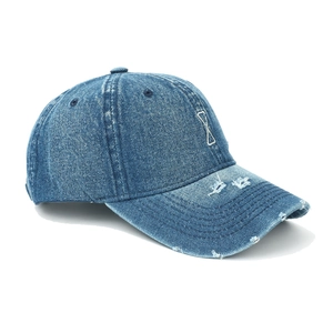 Detailed view of dark blue washed denim baseball cap with distressed ripped brim