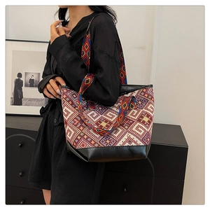 Ethnic style large tote bag with colorful geometric woven pattern shown on shoulder