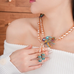 Vintage style necklace featuring champagne crystal beads and a gem-studded floral pendant