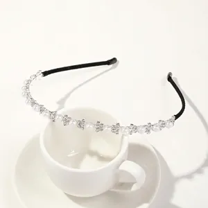 Detail of silver headband with alternating white pearls and rhinestones on a cup