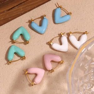 Detail of colorful enamel heart earrings in gold finish showing four pastel variants