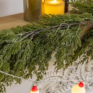 Deep green cypress needle garland 180cm displayed on a table with warm candles