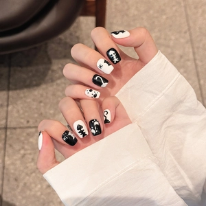 Minimalist black and white press-on nails with cute cat and fishbone art designs