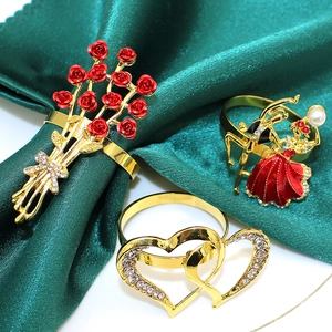 Golden metal napkin rings set featuring rose bouquet, dancing couple, and double heart shapes