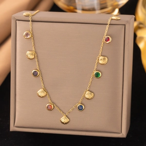 Détail d'un collier doré orné de pierres précieuses colorées et de pendentifs coquillages