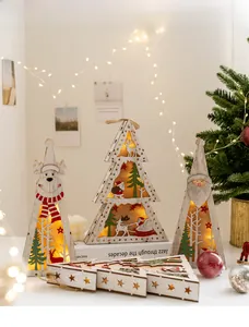 Detail of laser-cut wooden Christmas LED ornaments featuring reindeer and tree motifs