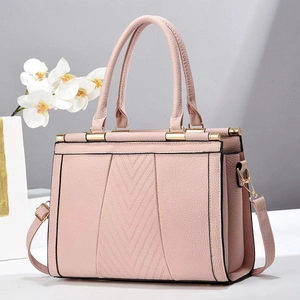 Détail du sac à main en cuir litchi rose clair avec coutures en V et boucles dorées
