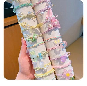 Close-up of elastic hair bands with colorful resin rabbits, pearls and floral charms