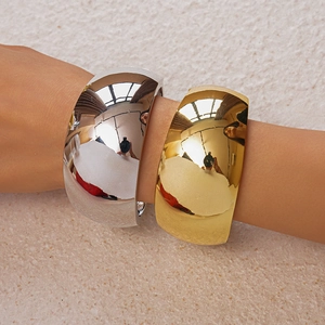 Detail of metallic irregular wide cuff bracelet showing high-shine polished finish