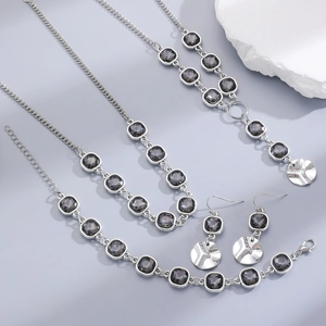Detailed set of silver necklace, bracelet, and earrings with square dark crystals