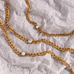 Detailed close-up of 18K gold-plated chain bracelet with marquise and round zircon pendants