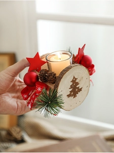 Detail of Christmas wooden candle holder with pine cones, red stars, and ornaments