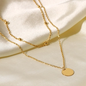 Macro view of 18K gold-plated double-layer necklace with bead chain and round pendant