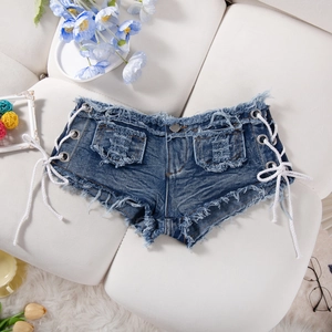 Dettaglio degli shorts in denim a vita bassa con lacci laterali e frange orlate