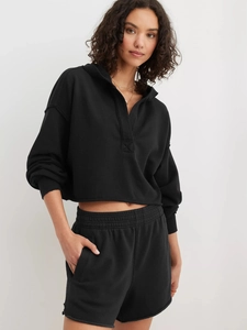 Detailansicht des schwarzen Cropped-Hoodies mit rohem Saum und passenden Shorts