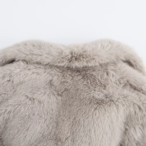 Detail shot showing the fluffy texture and soft collar of the grey faux fur coat