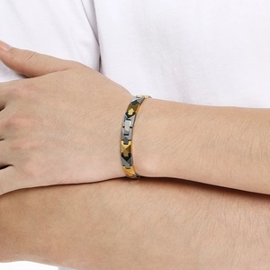Detailed close-up of a tri-color tungsten magnetic therapy bracelet on a male wrist