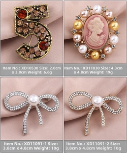 Detailed view of four vintage brooches with pearls and crystals on pink silk fabric