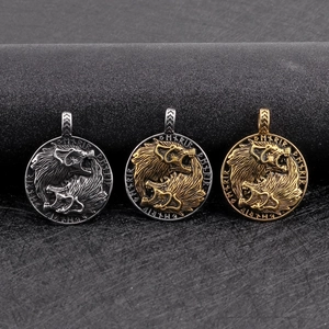 Close-up of three Viking wolf head pendants in silver and gold with Nordic runes