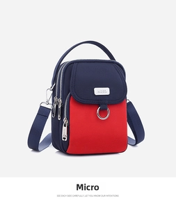 Side view of multi-compartment nylon phone bag with blue and red contrast panels