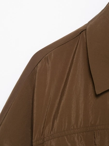 Détail du col de chemise style safari et couture d'épaule sur tissu coupe-vent brun