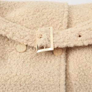 Chic beige boucle wool coat featuring a metallic gold belt buckle and textured buttons