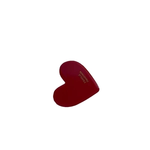 Red acetate heart-shaped hair clip with gold lettering on a white background