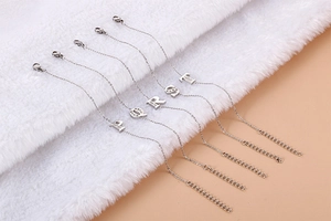 Close-up of silver-tone letter bracelets with rhinestones on a plush background