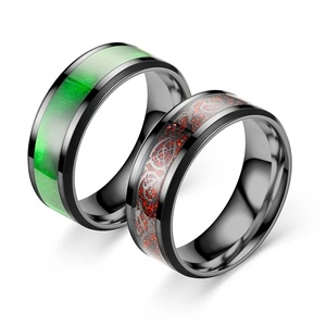 Close-up detail of fashion titanium steel rings featuring green and red patterned inlays