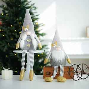 Christmas grey long-legged gnomes with gold sequins standing on a festive display