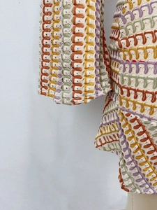 Dettaglio di un motivo all'uncinetto a zigzag colorato con trama a onde traforate miste