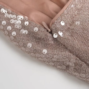 Detail of invisible zipper on pink sequined mesh fabric for party maxi dress