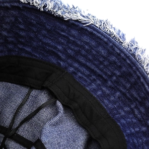 Détail du chapeau bob en denim bleu foncé avec bords effilochés et bande de propreté noire