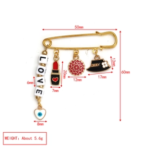 Detail view of a 50mm gold safety pin with Evil Eye, LOVE beads, and charms on white background