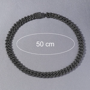 Close-up of 50cm black iced-out Cuban link chain with square buckle on grey surface