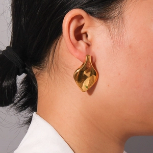 Minimalist teardrop geometric 18K gold plated earrings worn by a model in profile